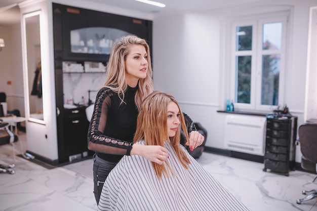 Peluquero y cliente tomando en salón