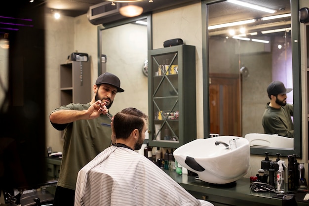 Peluquero cortando el cabello de un hombre en la peluquería