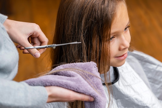 Foto gratuita peluquero cortando el cabello de niña