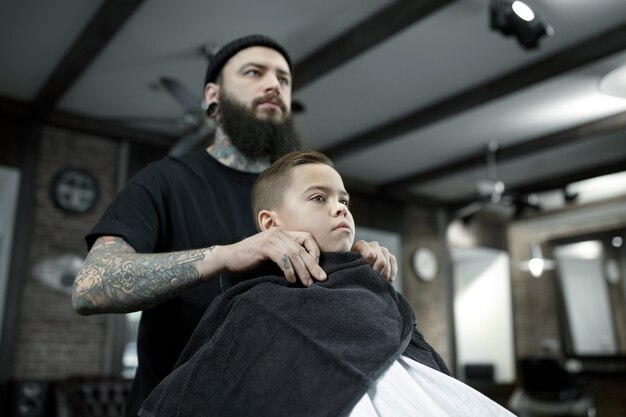 Peluquero cortando el cabello del niño