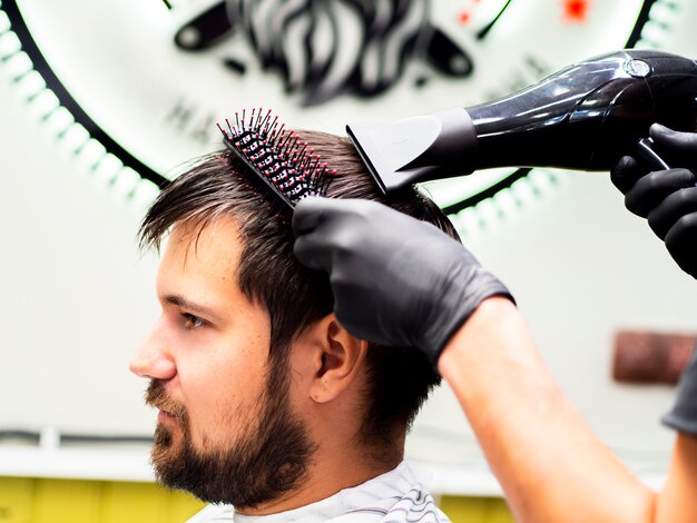 Peluquero haciendo un camino de pelo en el cabello de su cliente