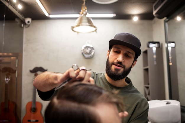 Foto gratuita peluquero masculino dando a su cliente un bonito corte de pelo