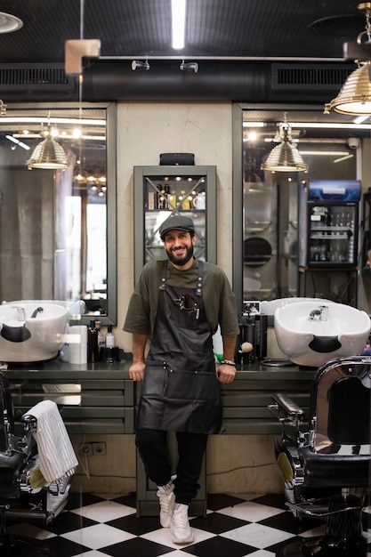 Foto gratuita peluquero masculino sentado en su tienda