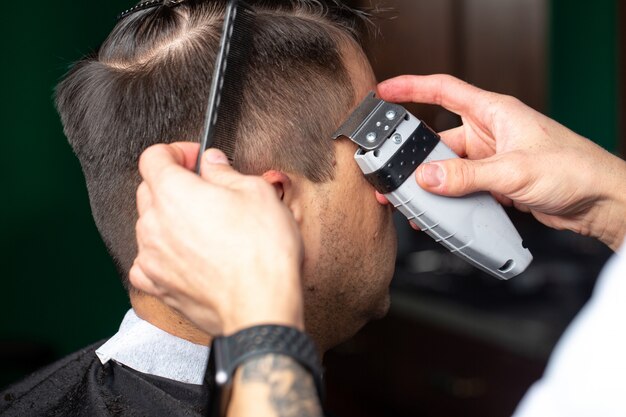 Peluquero mientras trabaja procces con corte de pelo