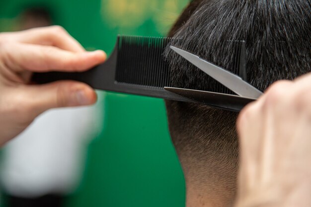 Peluquero mientras trabaja proceso con corte de pelo