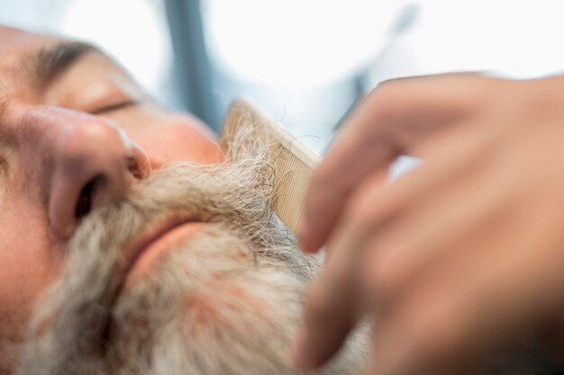 Peluquero peinando bigote al hombre