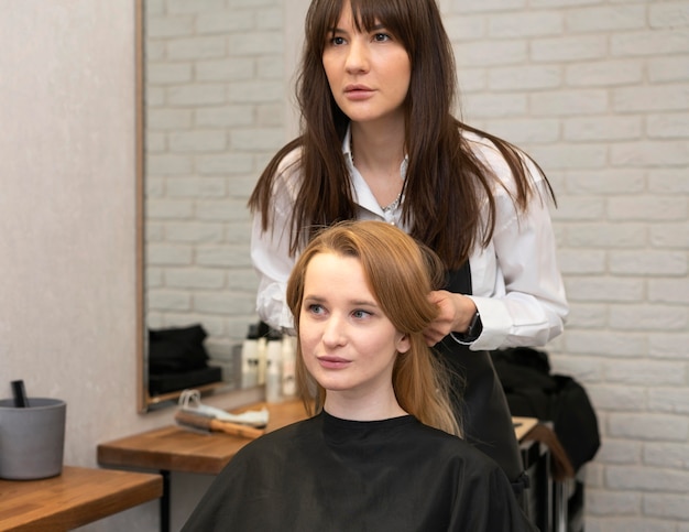 Foto gratuita peluquero peinando el cabello de un cliente