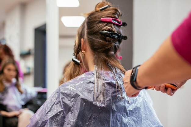 Peluquero teñir el cabello de una mujer