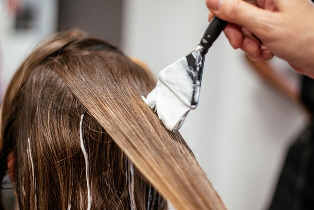 Peluquero teñir el cabello de una mujer