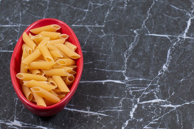 Penne de pasta cruda sin cocer en un tazón.