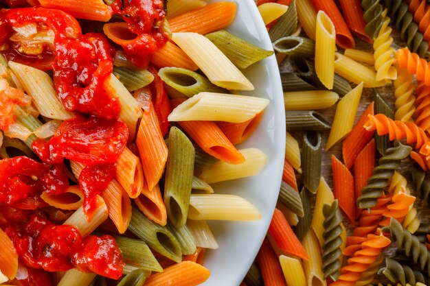 Penne pasta con salsa, tomate en un plato sobre pasta dispersa