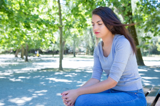 Pensativa jovencita descansando en el parque