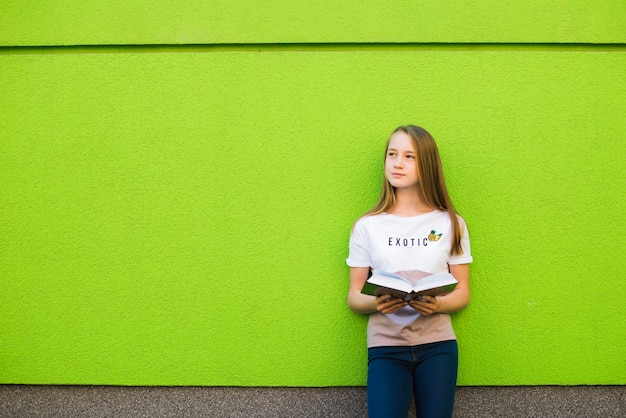 Foto gratuita pensativa niña con el libro de texto