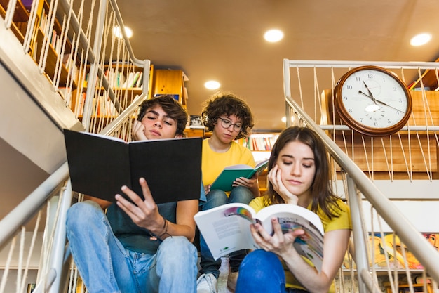 Foto gratuita pensativo adolescentes leyendo en pasos