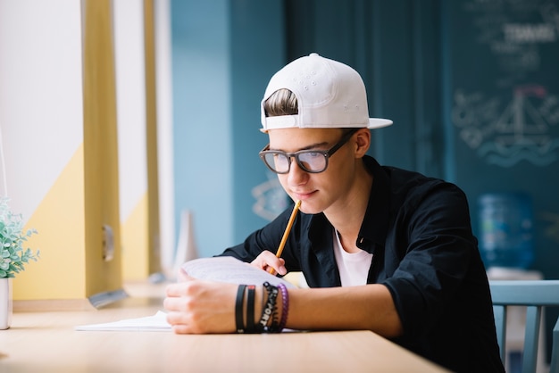 Pensativo estudiante trabajando en la tarea