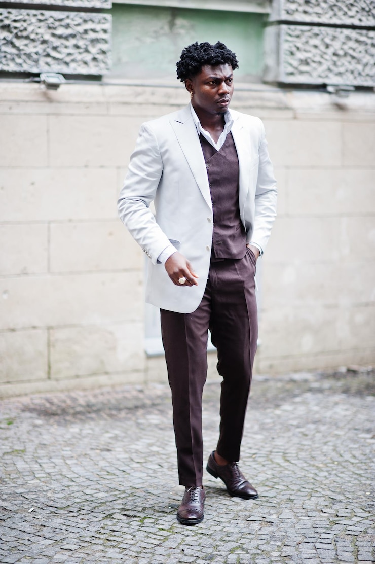 Foto gratuito pensativo joven apuesto caballero afroamericano en ropa formal modelo elegante negro hombre en chaqueta blanca