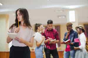 Foto gratuita pensativo niña posando en el fondo de los estudiantes