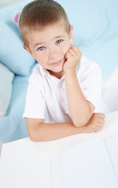 Pensativo pupil con camiseta blanca