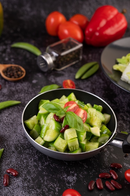 Foto gratuita pepino salteado con tomate y frijoles rojos en una sartén.