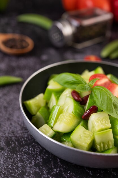 Foto gratuita pepino salteado con tomate y frijoles rojos en una sartén.