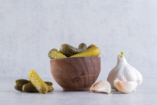 Pepinos encurtidos en cuencos colocados sobre la mesa de piedra.