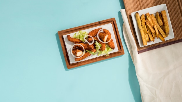 Pepitas fritas con vegetación y papas en rodajas