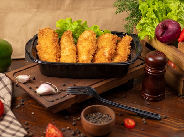 Pepitas de pollo frito estilo KFC para llevar en un recipiente negro
