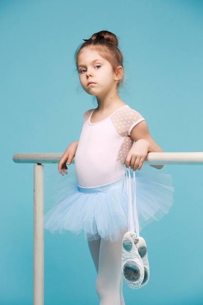 La pequeña bailarina bailarina sobre fondo azul.