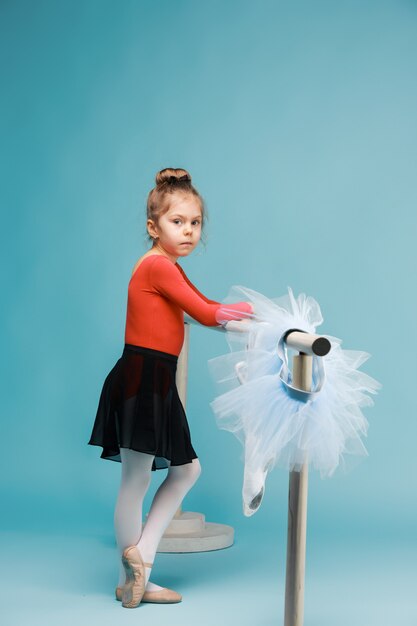 La pequeña bailarina de balerina sobre fondo azul.