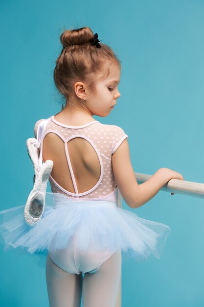 La pequeña bailarina de balerina sobre fondo azul.