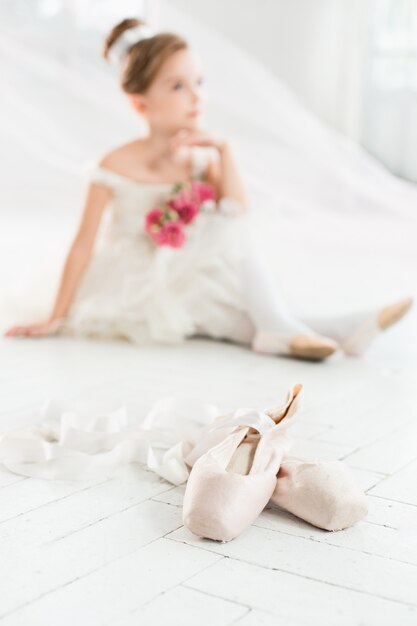 pequeña bailarina en tutú blanco en clase en la escuela de ballet