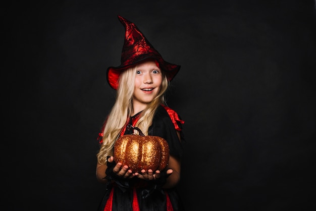 Foto gratuita pequeña bruja con calabaza