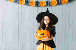 Foto gratuita pequeña bruja sonriendo en la fiesta de halloween