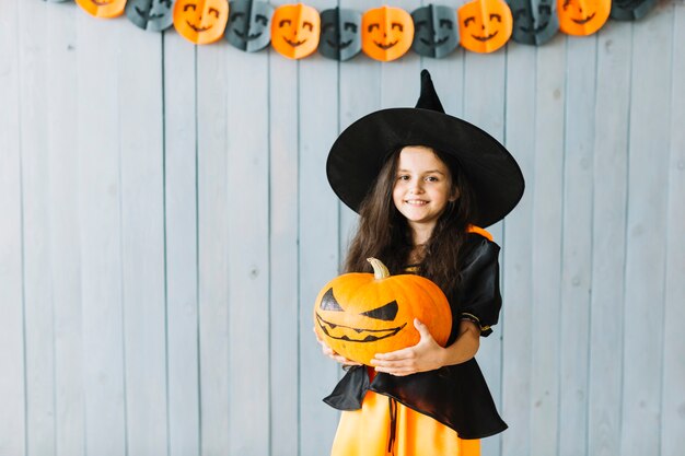 Pequeña bruja sonriendo en la fiesta de Halloween