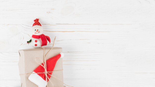 Pequeña caja de regalo con muñeco de nieve en mesa