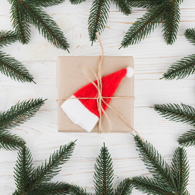 Pequeña caja de regalo con ramas verdes.