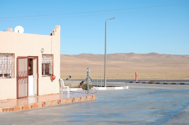 Pequeña casa cerca del camino hacia el desierto con cielo azul claro