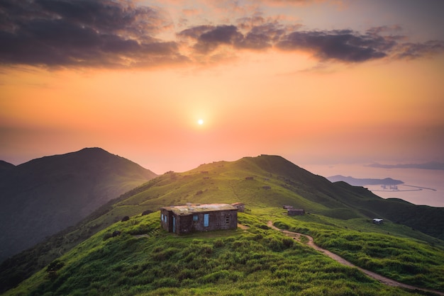 Pequeña casa construida en una tranquila colina verde en lo alto de las montañas