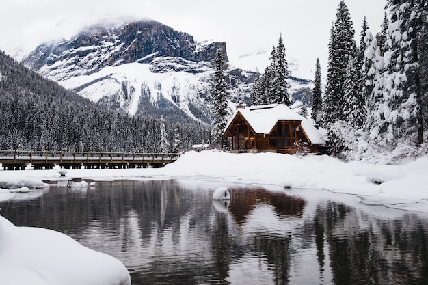 Pequeña casa de madera cubierta de nieve cerca del Lago Esmeralda en Canadá en invierno