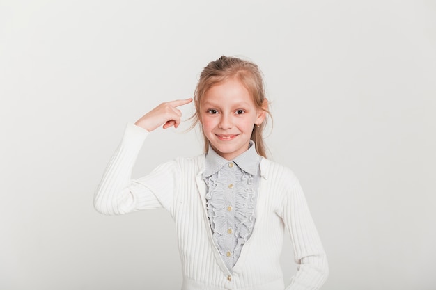 Pequeña chica apuntando hacia su cabeza