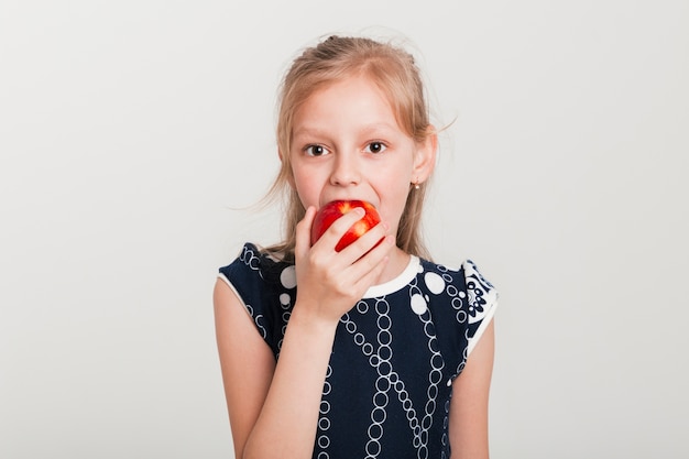 Pequeña chica comiendo una manzana