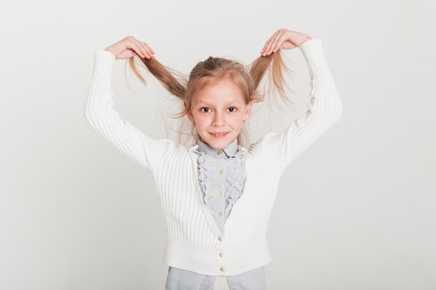 Foto gratuita pequeña chica levantando su pelo