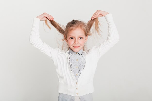 Pequeña chica levantando su pelo