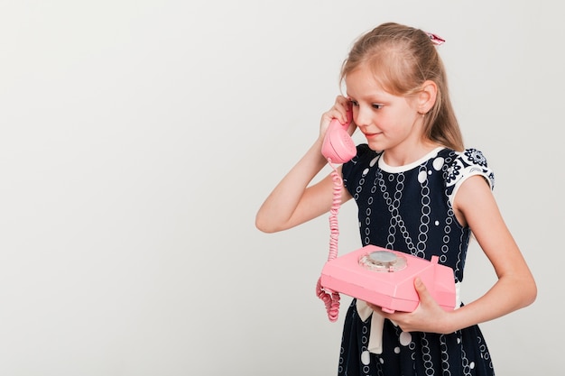 Pequeña chica llamando en teléfono vintage