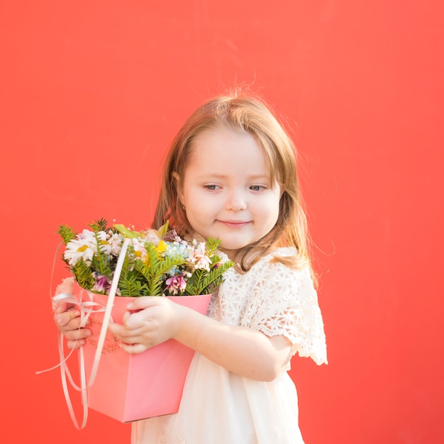 Foto gratuita pequeña dama de honor adorable sosteniendo flores