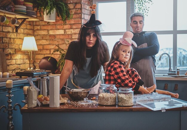 La pequeña familia está lista para Halloween, están cocinando algo especial en la cocina.