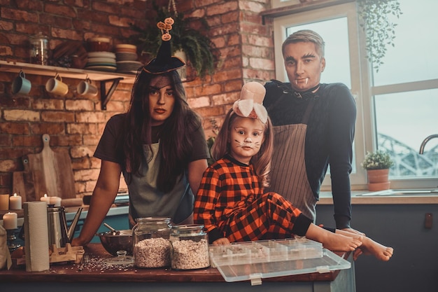 La pequeña familia está lista para Halloween, están cocinando algo especial en la cocina.