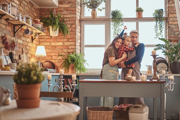 La pequeña familia feliz comienza el día juntos en la cocina.