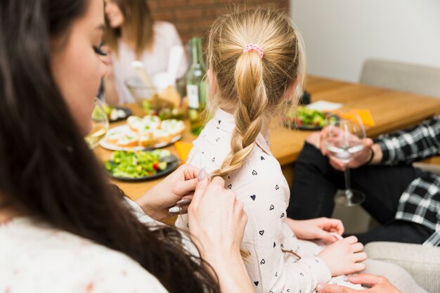 Pequeña hija sentada sobre las rodillas de la madre