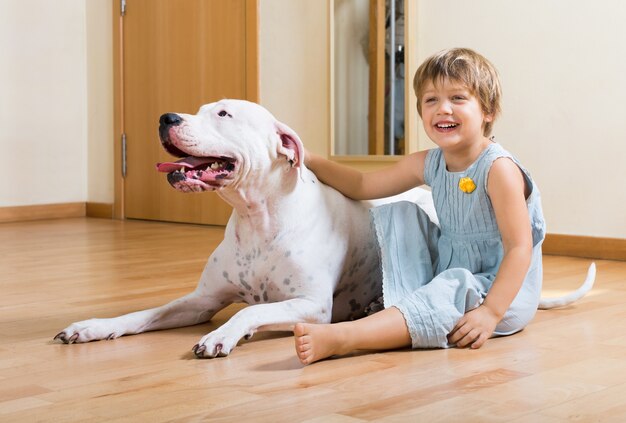 pequeña niña bonita en el piso con perro